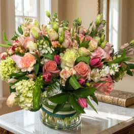 Mixed pink and white flowers arranged in a clear glass vase