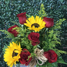 Red roses and yellow sunflowers in a wooden box