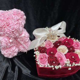 Pink rose teddy bear beside a heart-shaped rose box with a ribbon