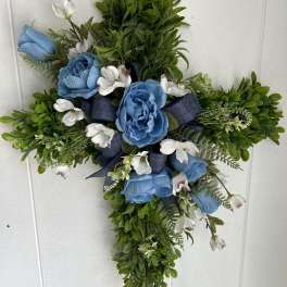 Cross-shaped floral arrangement with blue roses and white blossoms
