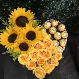 Heart-shaped bouquet of yellow roses and sunflowers with gold chocolates
