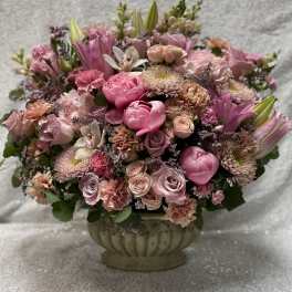 Pink mixed flower arrangement in a decorative urn vase