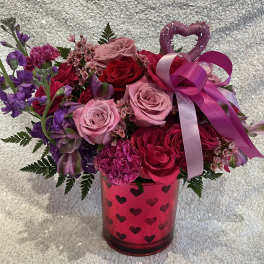 Pink and red rose bouquet in a heart-patterned vase with ribbon and heart topper
