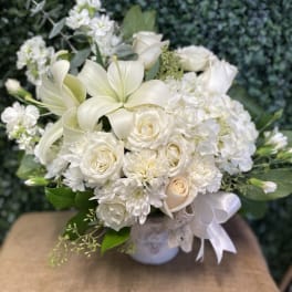 White floral bouquet with roses, lilies, and chrysanthemums in a vase