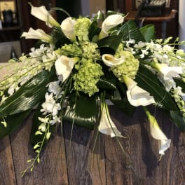 White calla lilies and orchids arranged with green hydrangeas