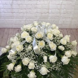 Large white rose arrangement with baby's breath and silver ribbon