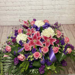 Large bouquet of pink roses, white hydrangeas, and pink lilies with purple ribbon
