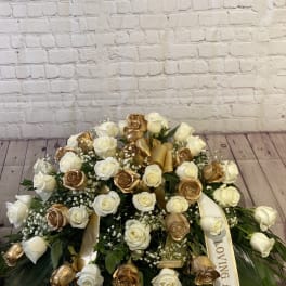 Large white and gold rose arrangement with a ribbon reading "Loving Angel"