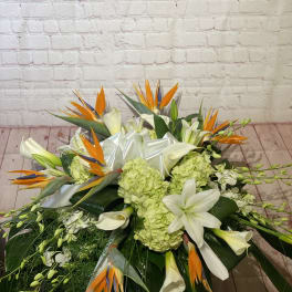 Large tropical floral arrangement with white lilies and orange bird-of-paradise