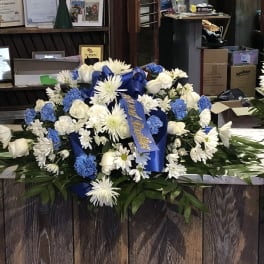 Large blue and white floral spray with ribbon on a counter