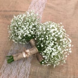 Two small white baby's breath bouquets tied with ribbon and lace