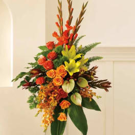 Tall floral arrangement with orange and yellow blooms on a stand