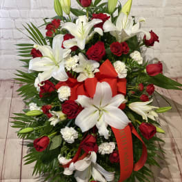 Red roses and white lilies arranged with a red ribbon
