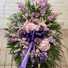 Large pink and purple floral spray with a purple ribbon bow