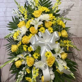 Large yellow and white floral spray with a white ribbon bow