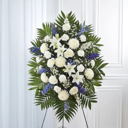 White and blue funeral spray on a standing easel