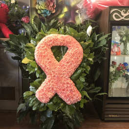 Pink floral awareness ribbon on a leafy standing display