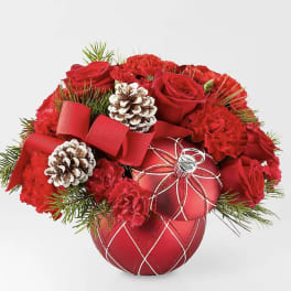 Red roses and carnations arranged with pinecones in a red ornament vase