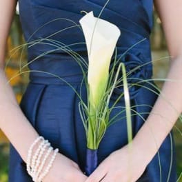 Woman holding a white calla lily bouquet with long grass accents
