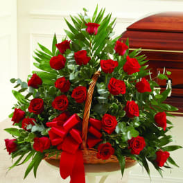 Basket arrangement of red roses with a red ribbon