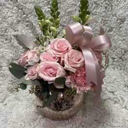 Pink rose arrangement in a glittery vase with a satin ribbon