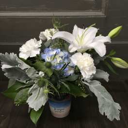 White lilies and carnations with blue hydrangea in a small container