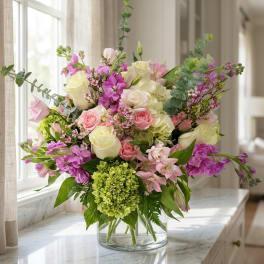 Mixed pink and white flower arrangement in a clear glass vase