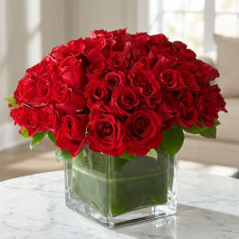 Red rose bouquet in a clear square glass vase