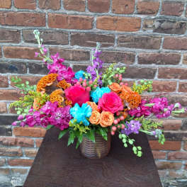 Colorful mixed flower arrangement in a ribbed glass vase