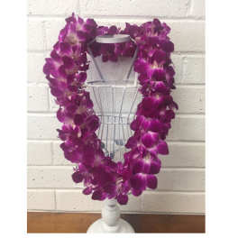Purple orchid lei draped over a white dress form