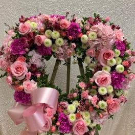 Pink and purple floral wreath with a satin ribbon on an easel