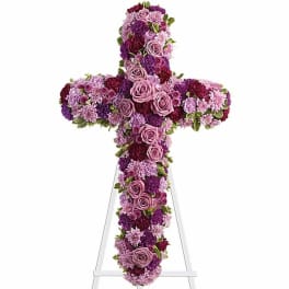 Purple and pink floral cross on a white stand