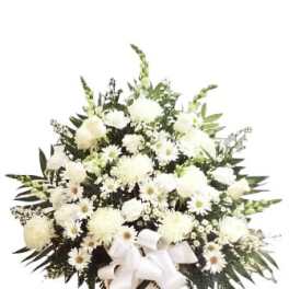 White floral standing spray with a ribbon on a pedestal