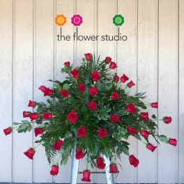 Large arrangement of red roses with greenery on a stand