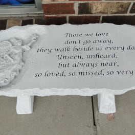 White memorial stone with an angel relief and engraved sympathy verse
