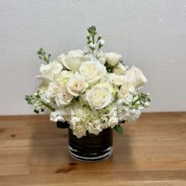 White rose bouquet in a dark glass vase