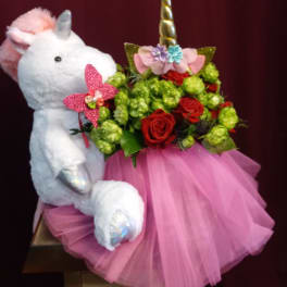 Plush unicorn holding a bouquet of red roses and green blooms