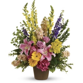 Mixed bouquet of lilies, roses, and daisies in a brown vase