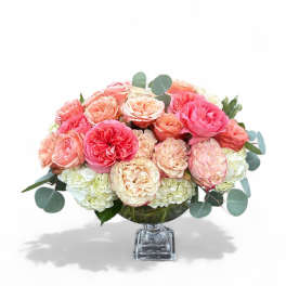 Pink and peach roses arranged in a clear glass vase