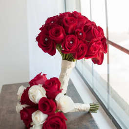 Two rose bouquets with red and white blooms, one tied with white ribbon