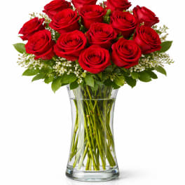 Red roses arranged in a clear glass vase