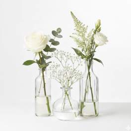 Three small glass vases with white flowers and baby’s breath