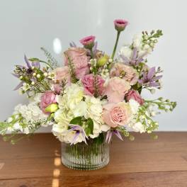 Pink and white floral arrangement in a clear glass vase