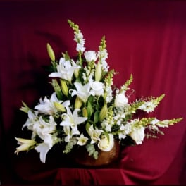White lilies and roses arranged in a low vase