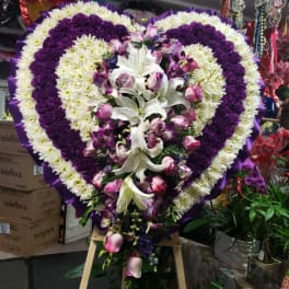 Heart-shaped floral standing spray with white, purple, and pink flowers
