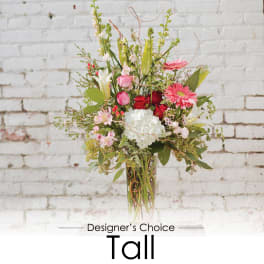 Tall mixed bouquet in a clear glass vase with pink, white, and red flowers