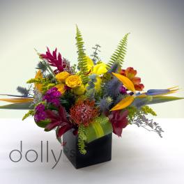 Tropical flower arrangement in a black cube vase with bright mixed blooms