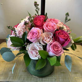 Pink and blush roses arranged in a low green vase