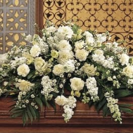 Large white floral casket spray with cascading blooms