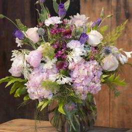 Mixed pink and purple flower arrangement in a glass vase